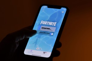 This illustration picture shows a person waiting for an update of Epic Games' Fortnite on their iPhone