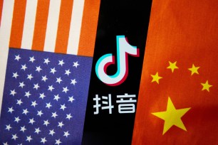 In this photo illustration a TikTok logo is seen displayed on a smartphone with a Chinese American flag on the background.