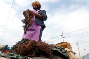 Julia Wanja, a hair stylist, sorts women's hair extensions to be recycled, at the Dandora dumpsite amid the coronavirus disease (COVID-19) outbreak in Eastlands Nairobi, Kenya.