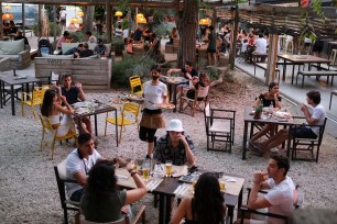 An employee carries pizzas for clients, who ordered them through the "Funky Pay" app, at Funky Pizza restaurant, where the app replaces waiters, in Palafrugell, near Girona, Costa Brava, Spain.