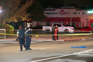 Police are seen at the scene of a shooting on Emmons Ave. and Bedford Ave. in Brooklyn today.