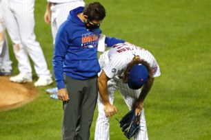 Robert Gsellman is tended to by a Mets trainer after straining his oblique during the Mets' 11-2 loss to the Orioles.