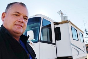 Eric Lewallen takes a photo of himself in front of his RV in La Crosse, Kansas.