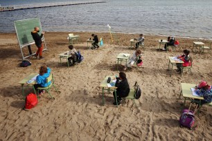 A teacher teaches a class to students of the Felix Rodriguez de la Fuente school, as part of a project known as 'Aire Limpio' (Fresh Air) at the Playa de los Nietos (The Grandchildren's Beach), which aims to use better air quality for children during the coronavirus pandemic, near Cartagena, southern Spain April 8, 2021.