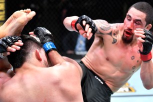 Robert Whittaker kicks Kelvin Gastelum during his UFC victory.