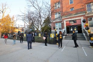 School officials welcome students at James Madison High School on March 22, 2021 in the Madison neighborhood of the Brooklyn borough in New York City.