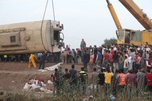 A crane lifts a damaged carriage of a passenger train that was derailed in Toukh, Al Qalyubia Governorate, north of Cairo, Egypt.