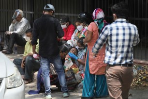 A woman comforts her relative as they wait to receive the body of a person who died of COVID-19 outside a mortuary, in New Delhi, India, Monday, April 19, 2021.