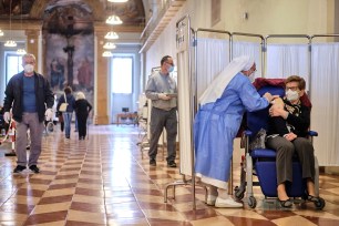 A health worker administers a dose of the Pfizer vaccine to a woman at the San Giovanni Addolorata hospital, in Rome, Saturday, April 10, 2021.