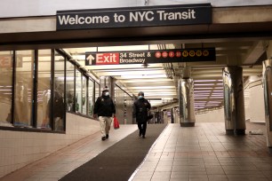 People in masks walk through a tunnel in the subway on May 21, 2020 in New York City.