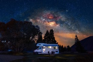 An RV in nature during a sunset.