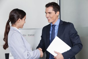 Business man and woman giving handshake in the office