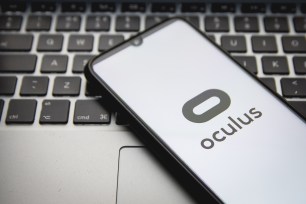 Oculus logo displayed on a smartphone with computer keyboard in background