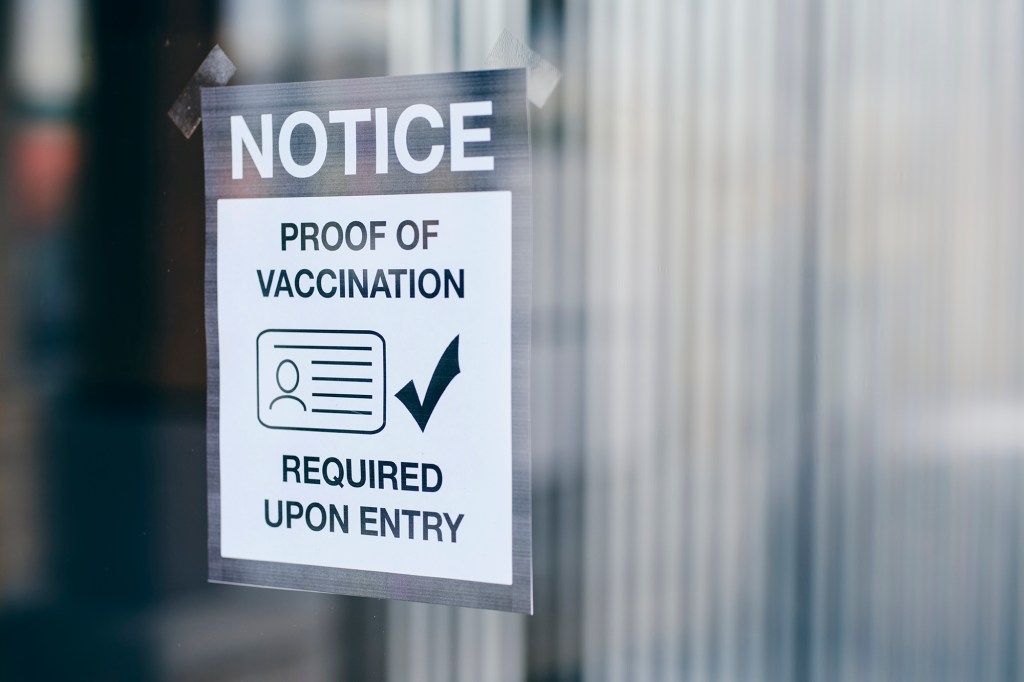 A business with a sign requiring proof of vaccination.