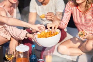 three individuals sharing a chip bowl