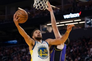 Stephen Curry, who scored 33 points, goes up for a layup as Matt Ryan defends during the Warriors' 123-109 season-opening win over the Lakers.