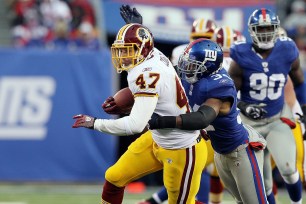 Deon Grant #34 of the New York Giants forces a fourth quarter fumble against Chris Cooley #47 of the Washington Redskins on December 5, 2010 at the New Meadowlands Stadium in East Rutherford, New Jersey. The Giants defeated the Redskins 31-7. (Photo by Jim McIsaac/Getty Images)