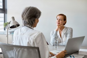 Doctor discussing with woman over laptop.