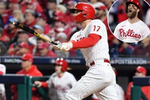 Rhys Hoskins hits the second of his homers in the fifth inning and Bryce Harper (inset) celebrates after an RBI double in the same frame in the Phillies' 10-6 victory over the Padres in Game 4 of the NLCS.