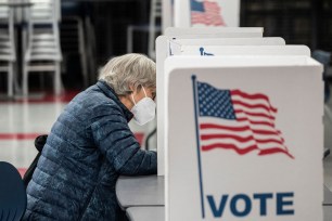 A voter fills in her ballot