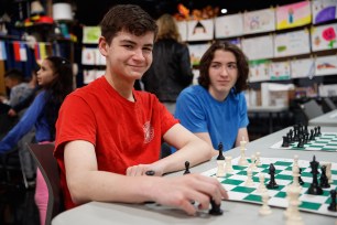 Stuyvesant sophomores Kyle Lancman (left) and his twin brother Kaleb Lancman (right) prepare to greet students at the after school Spanish language chess program in Times Square.