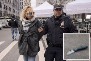 A woman protesting in support of former President Donald Trump is arrested by court officers for getting into an altercation with a pedestrian and brandishing a knife outside the District Attorney's office in New York, Tuesday, March 28, 2023. (AP Photo/Yuki Iwamura)