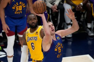 Nikola Jokic, who had 34 points, 21 rebounds and 14 assists, goes up for a shot as LeBron James looks on during the Nuggets' 131-126 Game 1 win over the Lakers.