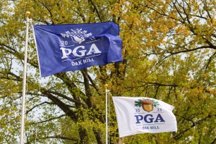 Winds whip the PGA Championship flags at Oak Hill golf course during a practice round. The first round is expected to be delayed due to frost.