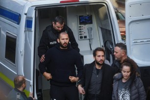 Andrew Tate and Tristan Tate are escorted by police officers outside the headquarters of the Bucharest Court of Appeal, in Bucharest, Romania, on February 1, 2023.