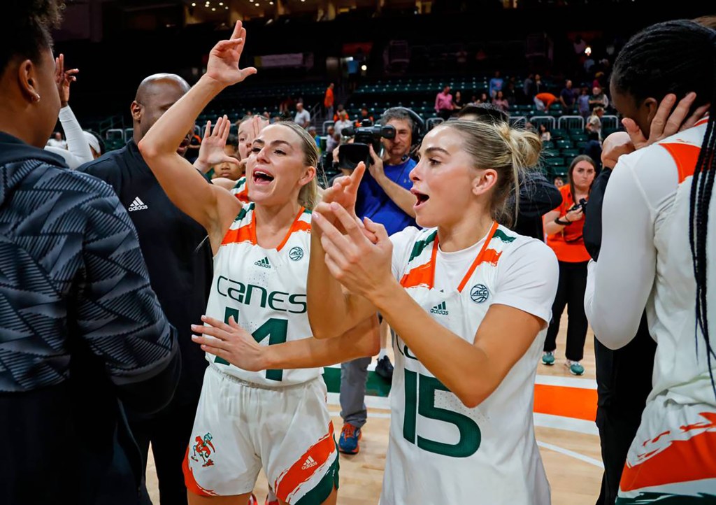 Miami's Haley Cavinder (14) and Hanna Cavinder (15) celebrate after the Hurricanes defeated Florida State at the Watsco Center on Feb. 9, 2023, in Coral Gables, Florida.