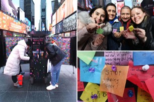 wishing wall in times square; people hold up their wishes