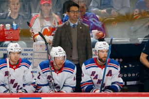 Rangers assistant coach Michael Peca stands behind the bench.