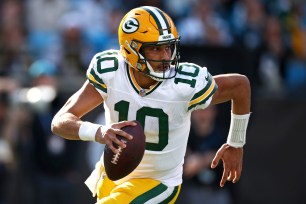 Jordan Love #10 of the Green Bay Packers runs with the football during the first half of the game against the Carolina Panthers.