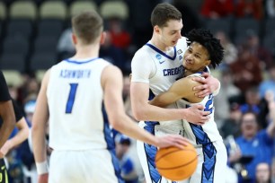 Ryan Kalkbrenner (left) and Trey Alexander hug as Steve Ashworth dribbles out the clock in Creighton's 86-73 double OT win over Oregon in the second round of the NCAA Tournament.