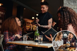 Young woman with a friend ordering to waiter holding digital tablet. Two women sitting at cafe holding menu card giving an order to male waiter.