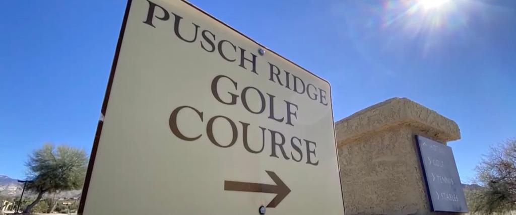 Sign for Pusch Ridge Golf Course with an arrow to the right.