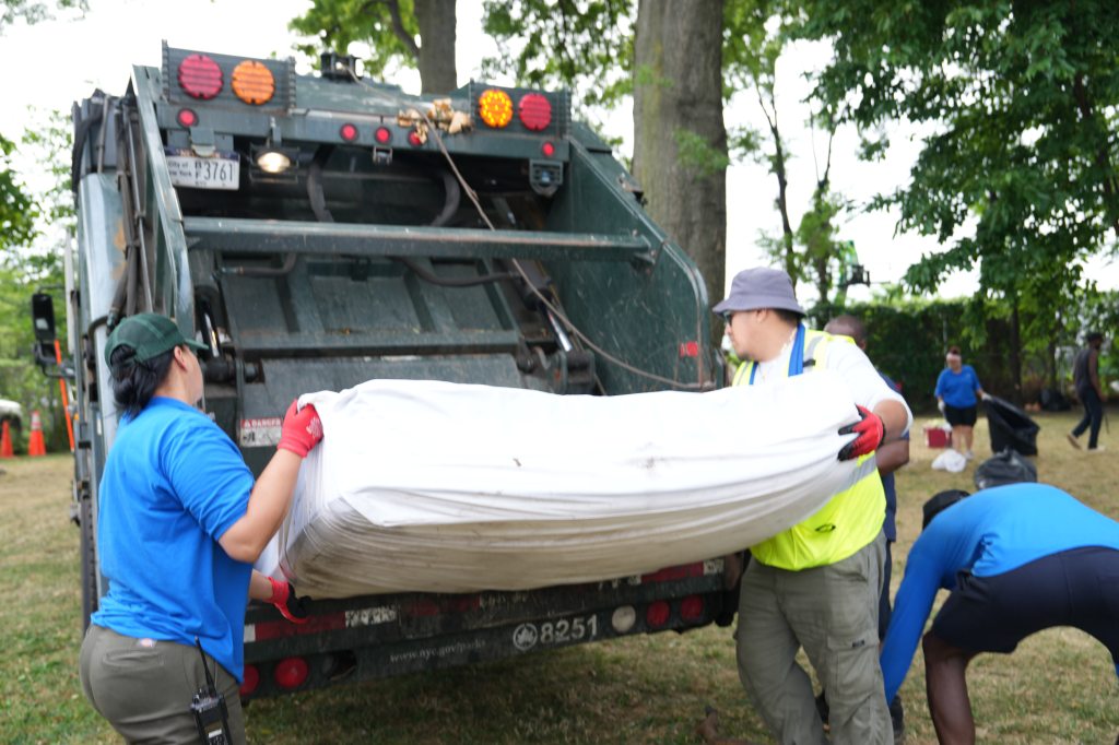 The NYPD and city workers cracked down on an illegal tent encampment on Randall's Island Friday -- hauling away mattresses and other items in garbage trucks. 