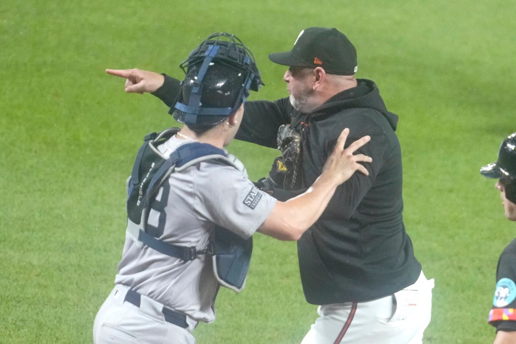 Catcher Austin Wells (L.) holds back Orioles manager Brandon Hyde during the Yankees' win over the Orioles on July 12, 2024. 