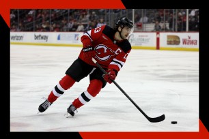 New Jersey Devils star Nico Hischier controls the puck on the ice.