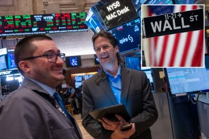 New York Stock Exchange traders and Wall Street sign