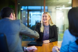 A student graduate sitting at a table with a man in a suit for a job interview