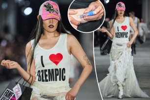 A model in a white shirt and pink hat walking the runway at the Namilia show during Berlin Fashion Week SS25