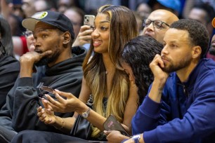 Angel Reese (center) sits with Kevin Durant and Stephen Curry during the U.S. women's showcase game against Germany.