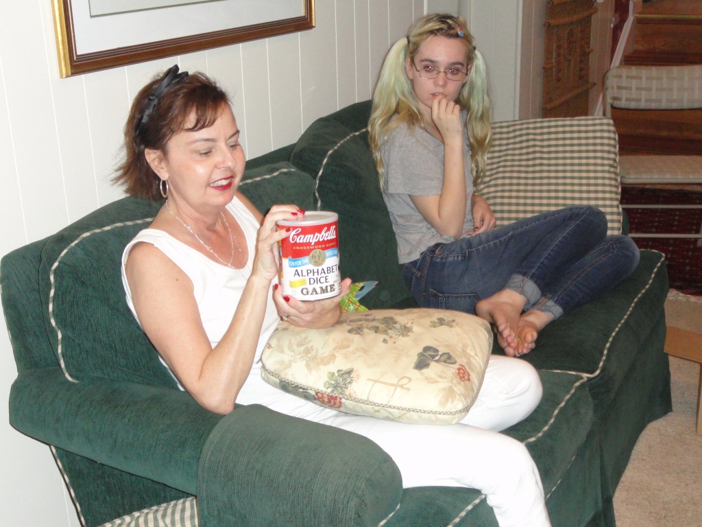 A very anorexic, young Prisha Mosley sitting on a couch.