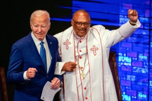 President Joe Biden locks arms with Bishop Ernest C. Morris Sr., prior to delivering remarks at Mount Airy Church of God in Christ in Philadelphia, Pennsylvania.