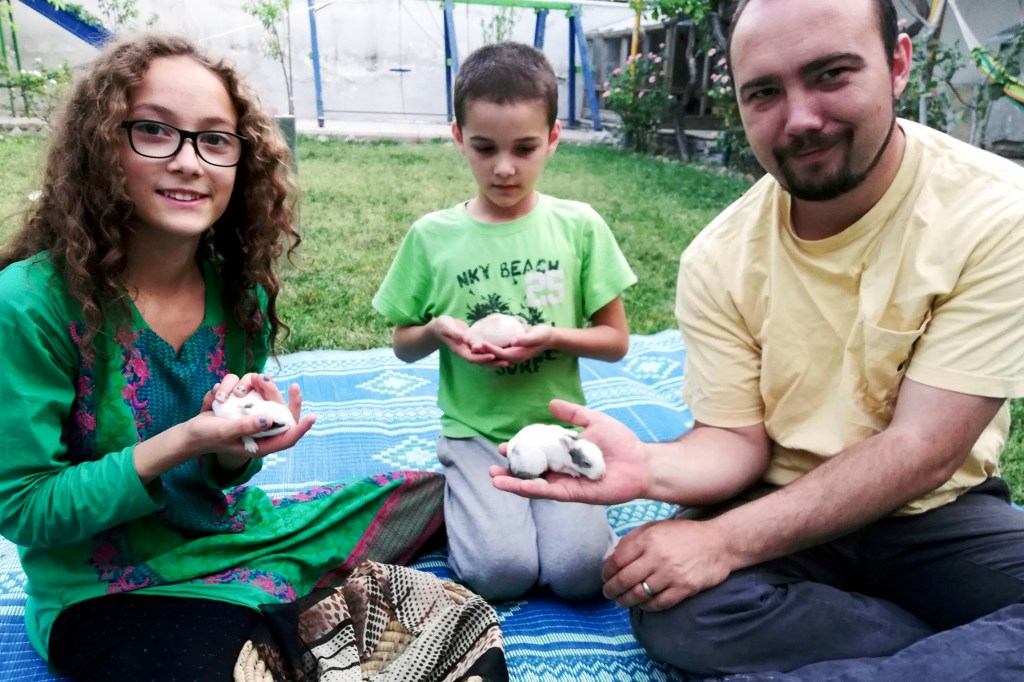 This family photo shows Ryan Corbett holding rabbits with his daughter Miriam and son Caleb in Kabul, Afghanistan in 2020.