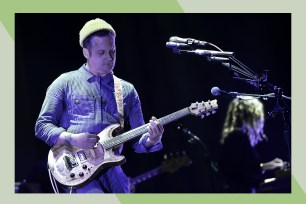 Modest Mouse frontman Isaac Brock plays guitar while wearing a beanie.