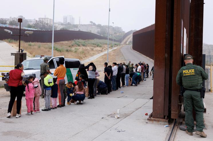 Border Patrol agents gather and sort migrants who overnight gathered between the border walls that separate Mexico and the United States following the announcement of tough new restrictions imposed by U.S. President Biden in California, June 6, 2024.