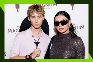 Troye Sivan (L) and Charli XCX pose on the red carpet.