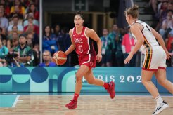 Kelsey Plum in a red uniform running with a basketball